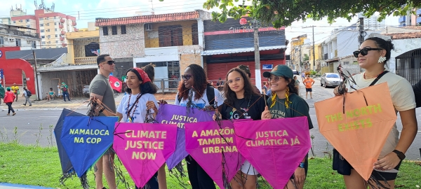 Fünf Frauen halten Transparente hoch mit der Forderung nach Klimagerechtigkeit